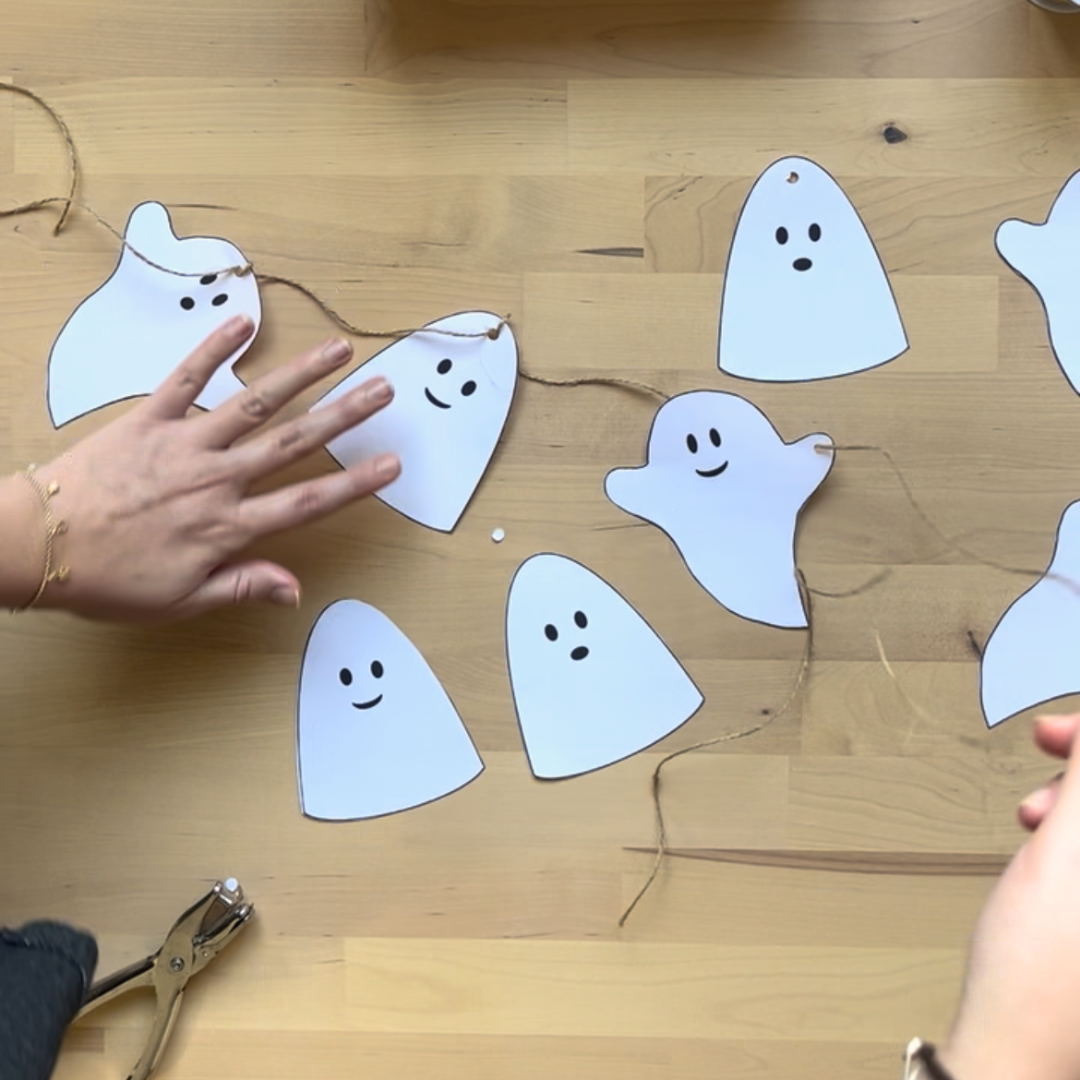 Maestra organizando guirnalda de fantasmas