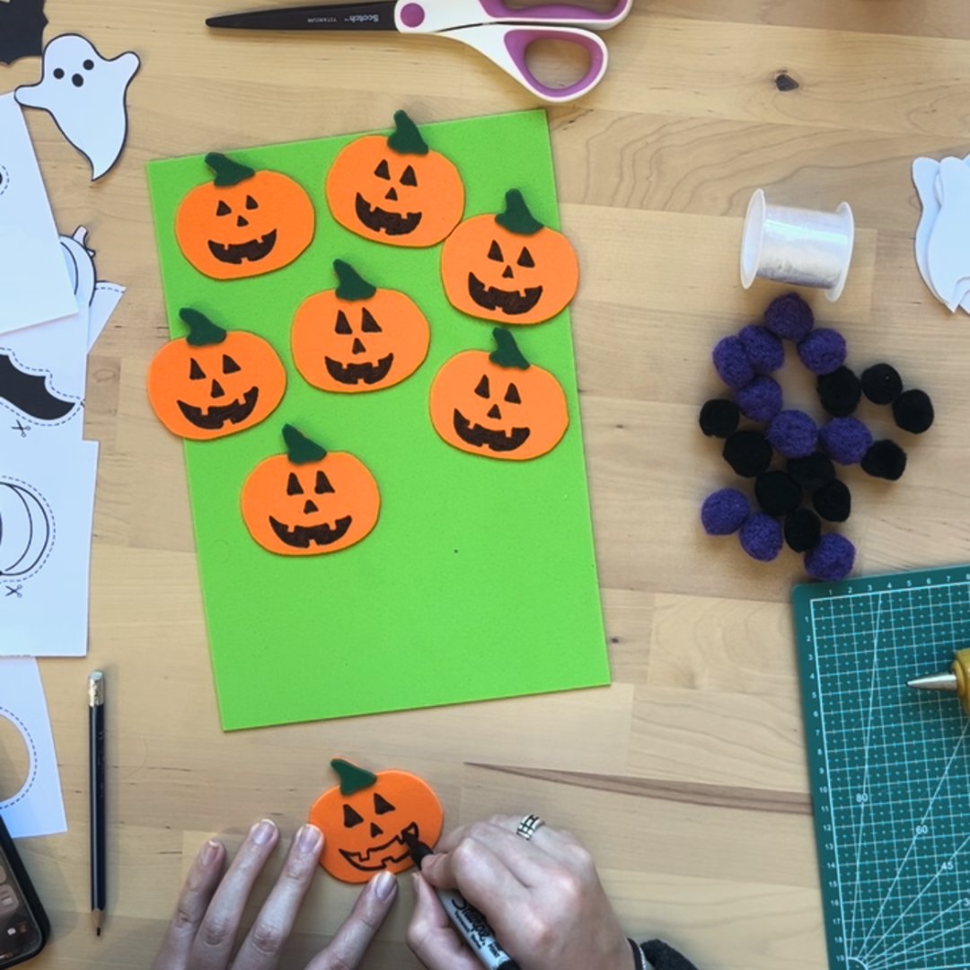 Maestra haciendo detalles al colgante de Halloween