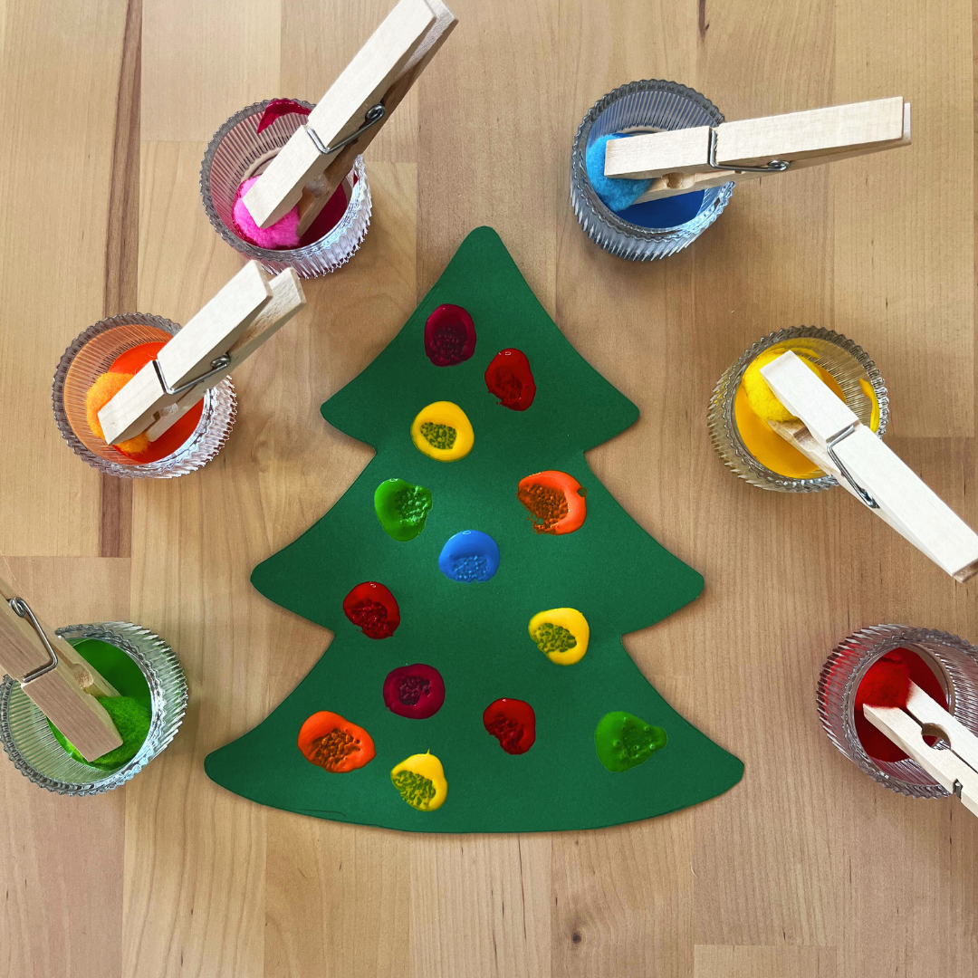 Árbol de navidad con guirnaldas pintadas con pompones y témpera