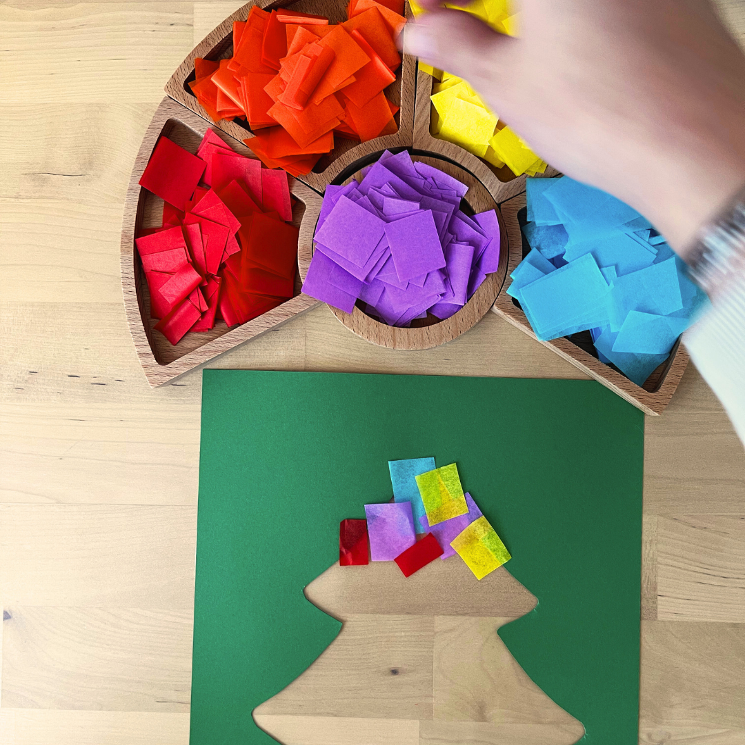Maestra colocando papel de seda para crear el efecto de vidriera en el árbol