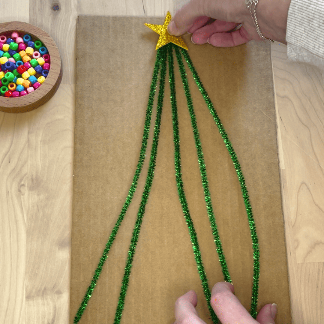 Maestra pegando la estrella en el árbol del juego