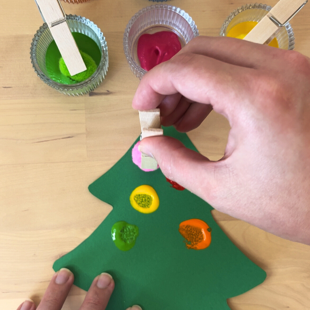 Maestra estampando círculos en árbol de navidad
